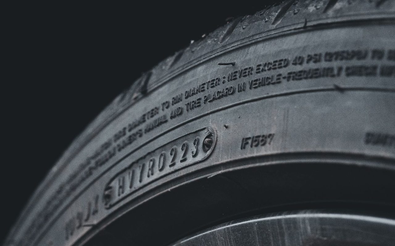 Close-up of a car tire sidewall showing its size markings and tread